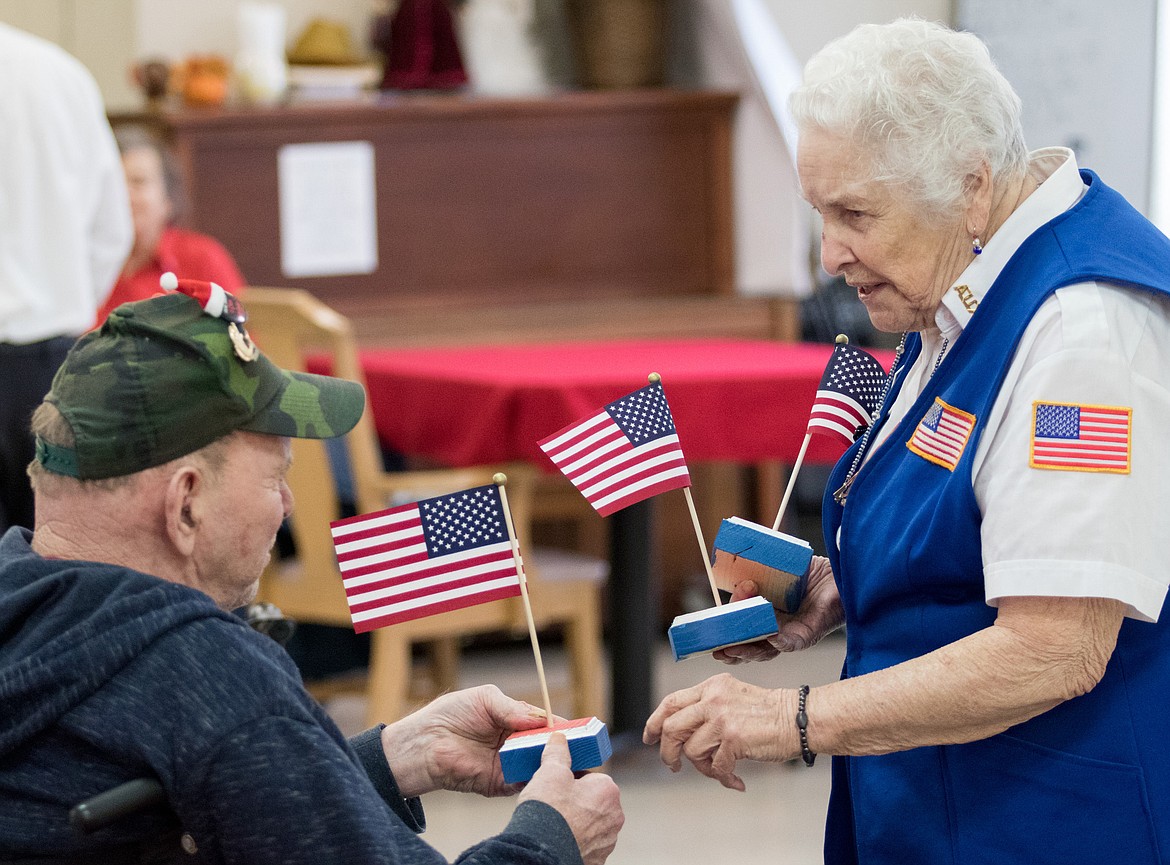 Stella Sharp, right, of the Libby VFW Post No. 1548 hands a flag to veteran Jerry Duncan at the Libby Care Center on Saturday, Nov. 11. (John Blodgett/The Western News)