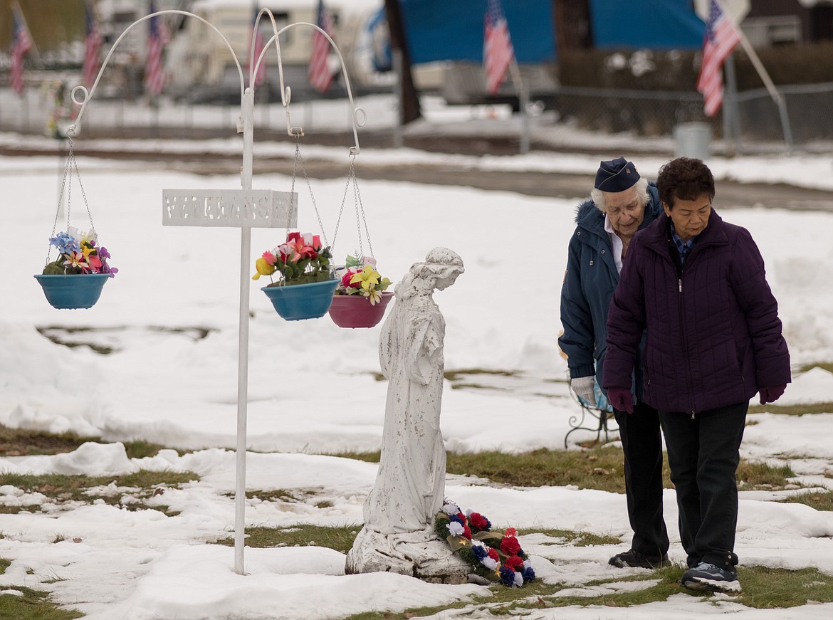 Blue Star mothers Stella Sharp, left, and Maria Wegner leave wreaths in honor of veterans during a Veterans Day memorial service at Libby Cemetery Saturday, Nov. 11. (John Blodgett/The Western News)