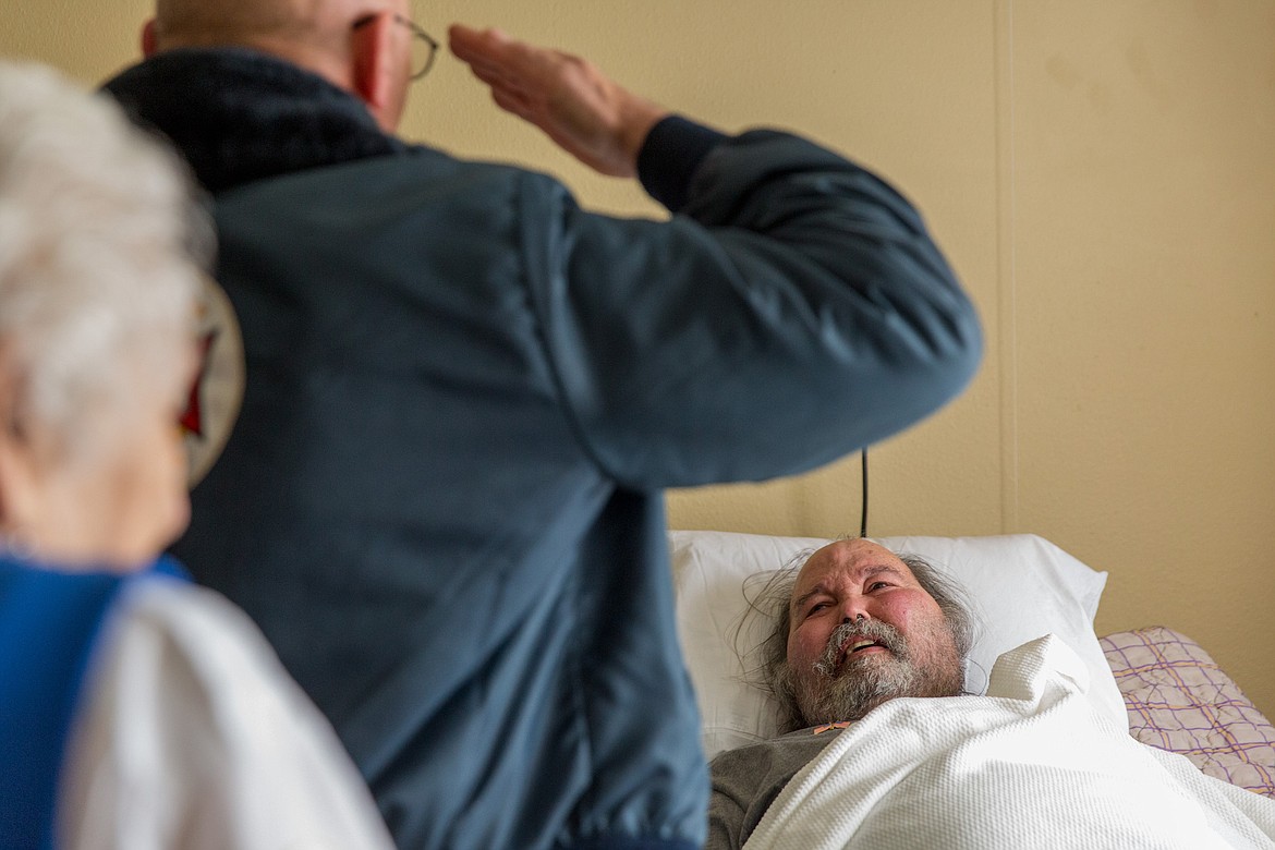 Gary Zoutte, commander at Libby VFW Post No. 1548, salutes veteran Duaine Shultz at Libby Care Center Saturday, Nov. 11. (John Blodgett/The Western News)