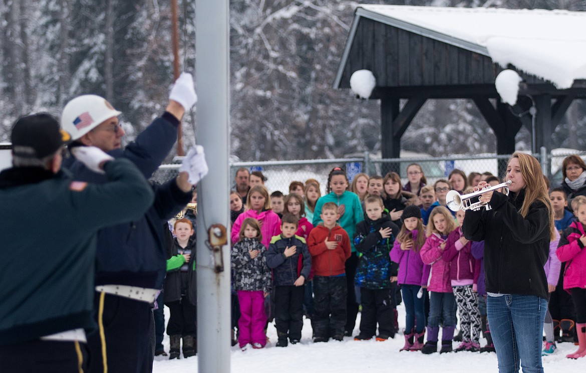 Libby student Cerria Swagger, right, plays taps as the American flag is raised at Libby Elementary School during a Friday morning Veterans Day assembly. (John Blodgett/The Western News)