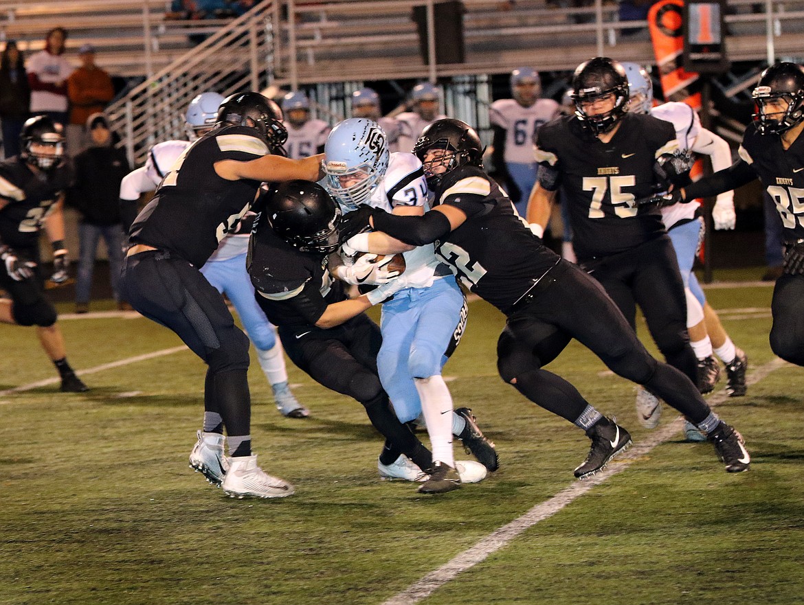 Pete Christensen Photo - Ramses Gonzalez (left), Jack Diaz (center) and Isaac Ellis wrap up Freeman running back Konner Freudenthal. The Knights beat the Scotties 35-0 and will take on Okanogan at the Apple Bowl in Wenatchee Friday.