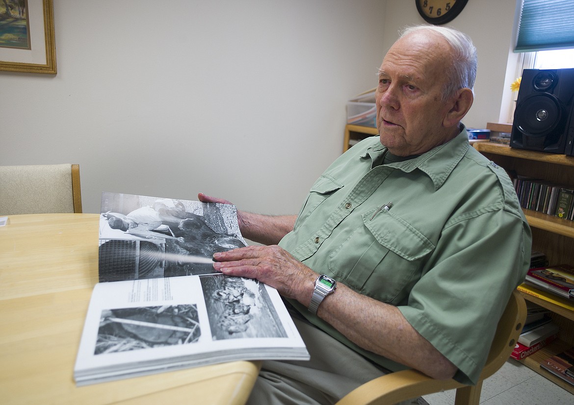 Louis Kis looks over some old photos of himself with a grizzly bear that Mel Ruder took in the book, &#147;Pictures, Park and a Pulitzer.&#148;