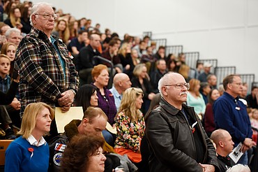 Rod Samdahl, and other Marines stand for the playing of the Marines Hymn during the Veterans Day Community Event at Whitefish High School on Friday, November 10.(Brenda Ahearn/Daily Inter Lake)