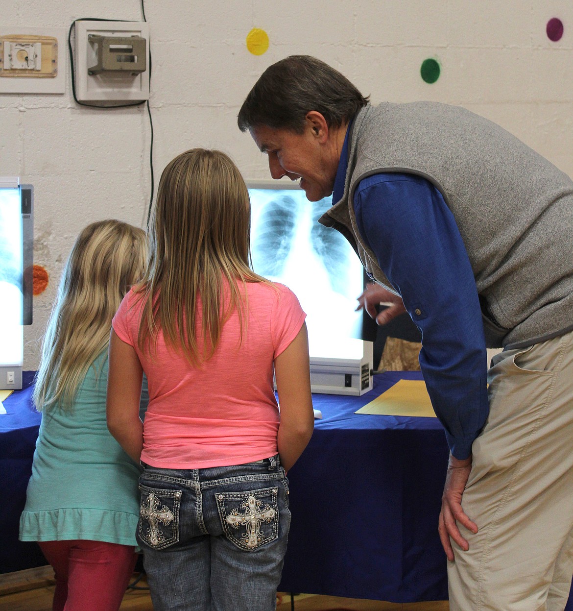 At the annual CARD Rally on Nov. 2, the CARD Clinic&#146;s Dr. Brad Black explains to two young visitors how x-rays work and shows the difference between a normal x-ray and an x-ray of someone with asbestos related disease. &#147;Each year we put on a community event to help educate about Libby Amphibole Asbestos and the health effects,&#148; Dusti L. Thompson, CARD Outreach Specialist, said via email. &#147;We make it family friendly and fun by having participants work through interactive stations, each simulating an obstacle that people with ARD may encounter. This was the eighth year of hosting the event and we had 175 children come through in 2 hours (and a) total of 325 people.&#148; (Courtesy photo)
