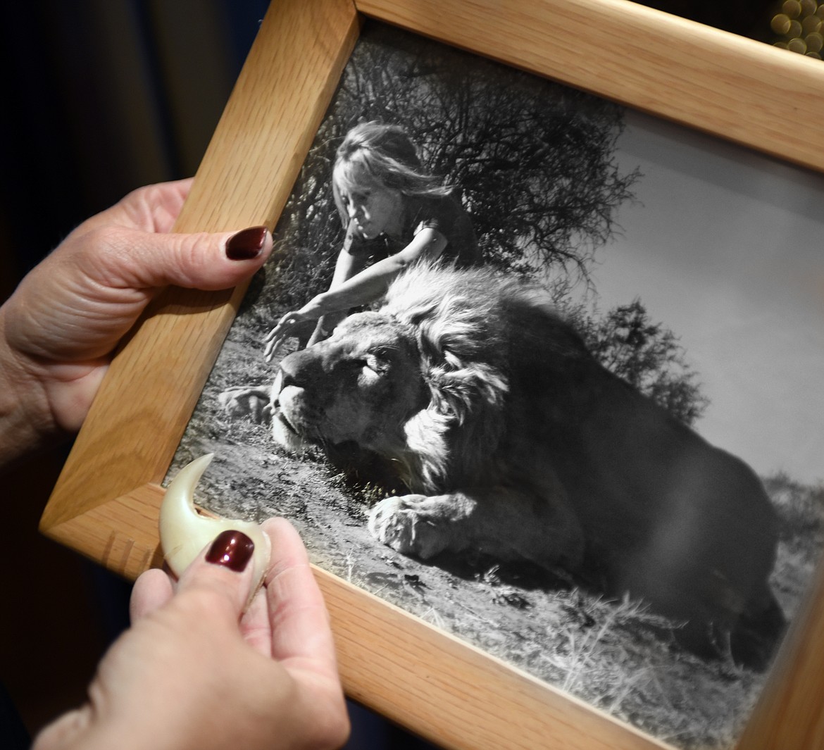 Olivia Opre holds a photo of herself and a lion she killed in Africa along with one of his claws. Opre says she is adamant about the rules and ethics of hunting.