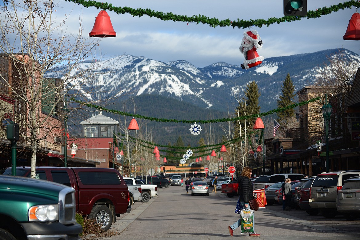 A shopper crosses Central Avenue at East Second Street in Whitefish during a Small Business Saturday event Nov. 25. (Casey Kreider/Daily Inter Lake)
