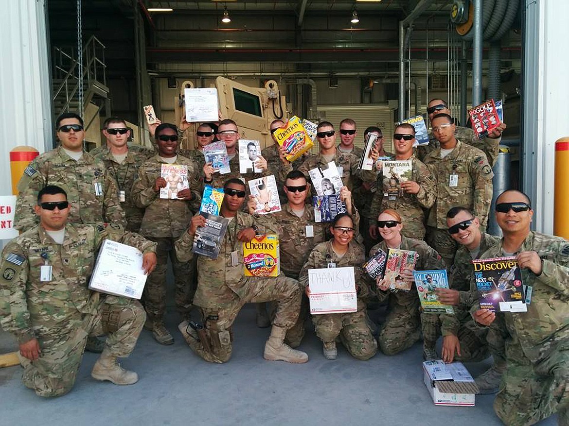 Army Staff Sgt. Al Paras Liwanag, far right, and members of the 543rd Military Police Company are pictured holding magazines sent by Magazines for Troops in 2014. (Photo courtesy of Al Paras Liwanag)