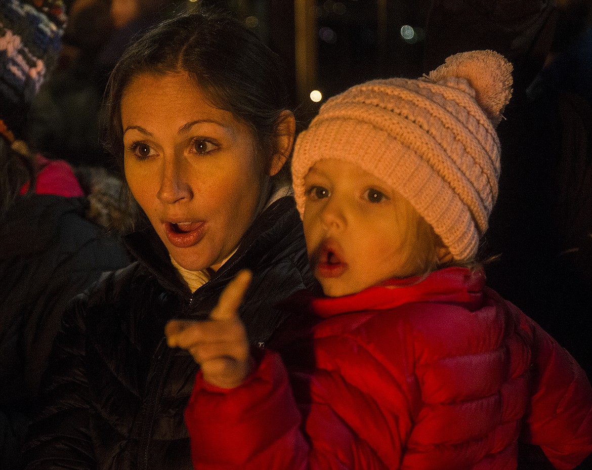 LOREN BENOIT/PressAbbie Gebbers and Beau Marie, 3, watch flames spew from a fire breathing dragon Tuesday night aboard a Journey to the North Pole Cruise boat.