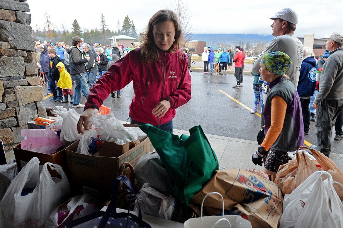 Petra Fortner of Whitefish drops off items for the North Valley Food Bank before the start of the Whitefish Turkey Trot on Thursday morning, Nov. 23. (Casey Kreider/Daily Inter Lake)