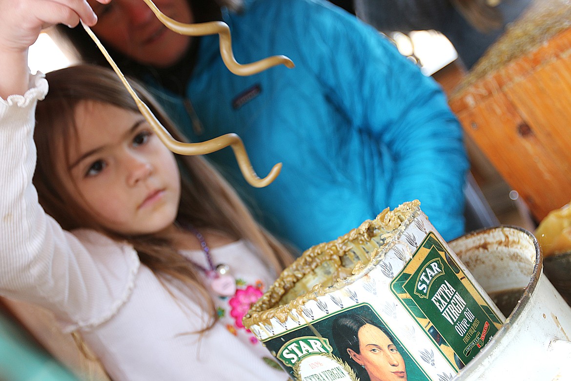 (File photo/CAROLINE LOBSINGER)
A young Sandpoint Waldorf student concentrates as she dips her candles into the beeswax at the school's annual Christmas Faire.