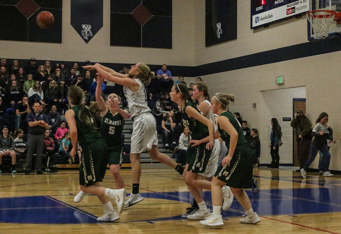 Photo by Mandi Bateman
Jerzie Pluid passes the ball to a teammate after being surrounded by the opposing team members.