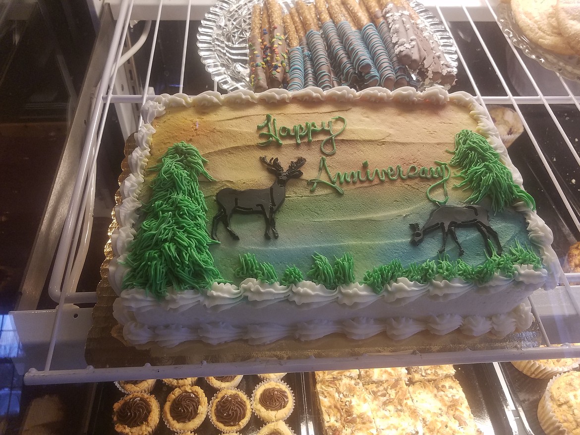 A rustic cake made by Selkirk Sweets with candy dipped pretzel sticks making an appearance behind it.