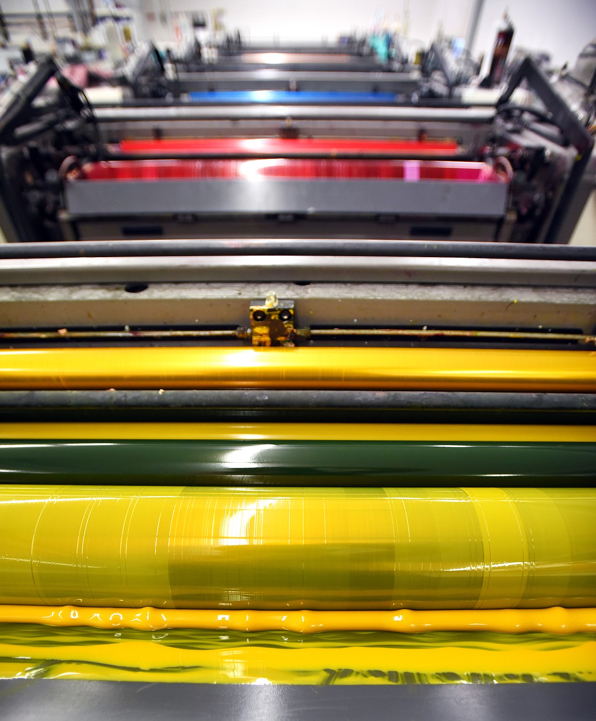 A view from above a large printer at Thomas Printing shows the standard yellow, magenta, cyan and black inks that make up the four-color printing process. (Brenda Ahearn/Flathead Journal)