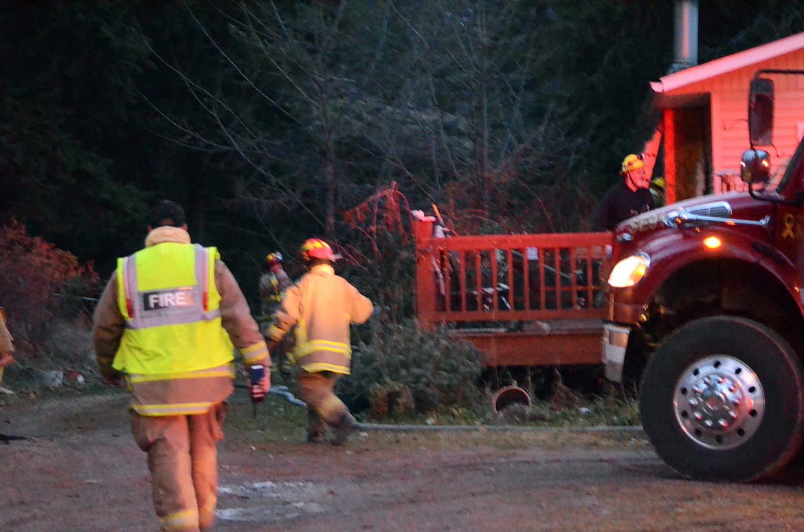 Fire Fighters get ready to clear out damage goods from the kitvhen after the blaze was successfully put out. (Erin Jusseaume/ Clark Fork Valley Press)