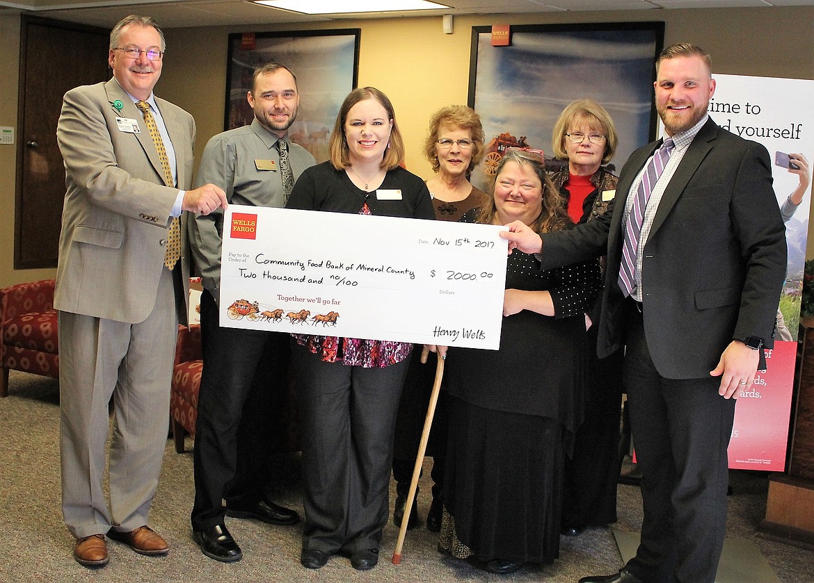 Mineral Community Hospital CEO Ron Gleason (far left), along with Wells Fargo bank employees, helps to present Bonnie Fuller (second from right, front row) with a check for $2,000 for the Lucky Lil&#146;s/Town Pump food drive. Wells Fargo&#146;s Dan Paulsen (far right) drove from Missoula for the presentation. (Kathleen Woodford/Mineral Independent)