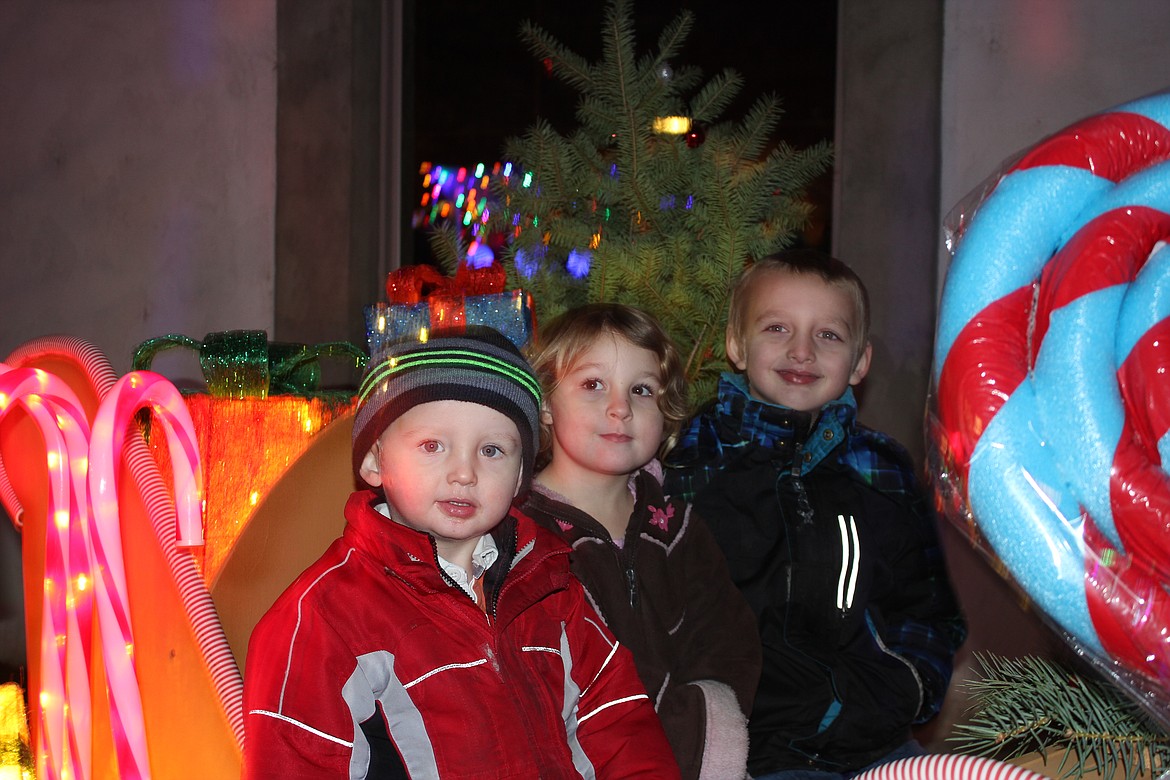 Photo by Tanna Yeoumans
Xavier, Jazmyn, and Dominique Redford pose for a picture in the sleigh after seeing Santa.