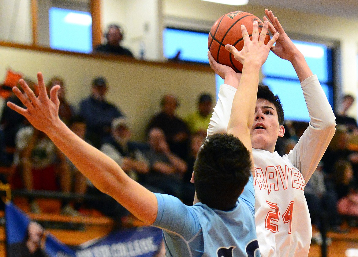 Flathead&#146;s Oz Allen shoots over Great Falls defender Blake Thelen in the first quarter. (Casey Kreider/Daily Inter Lake)