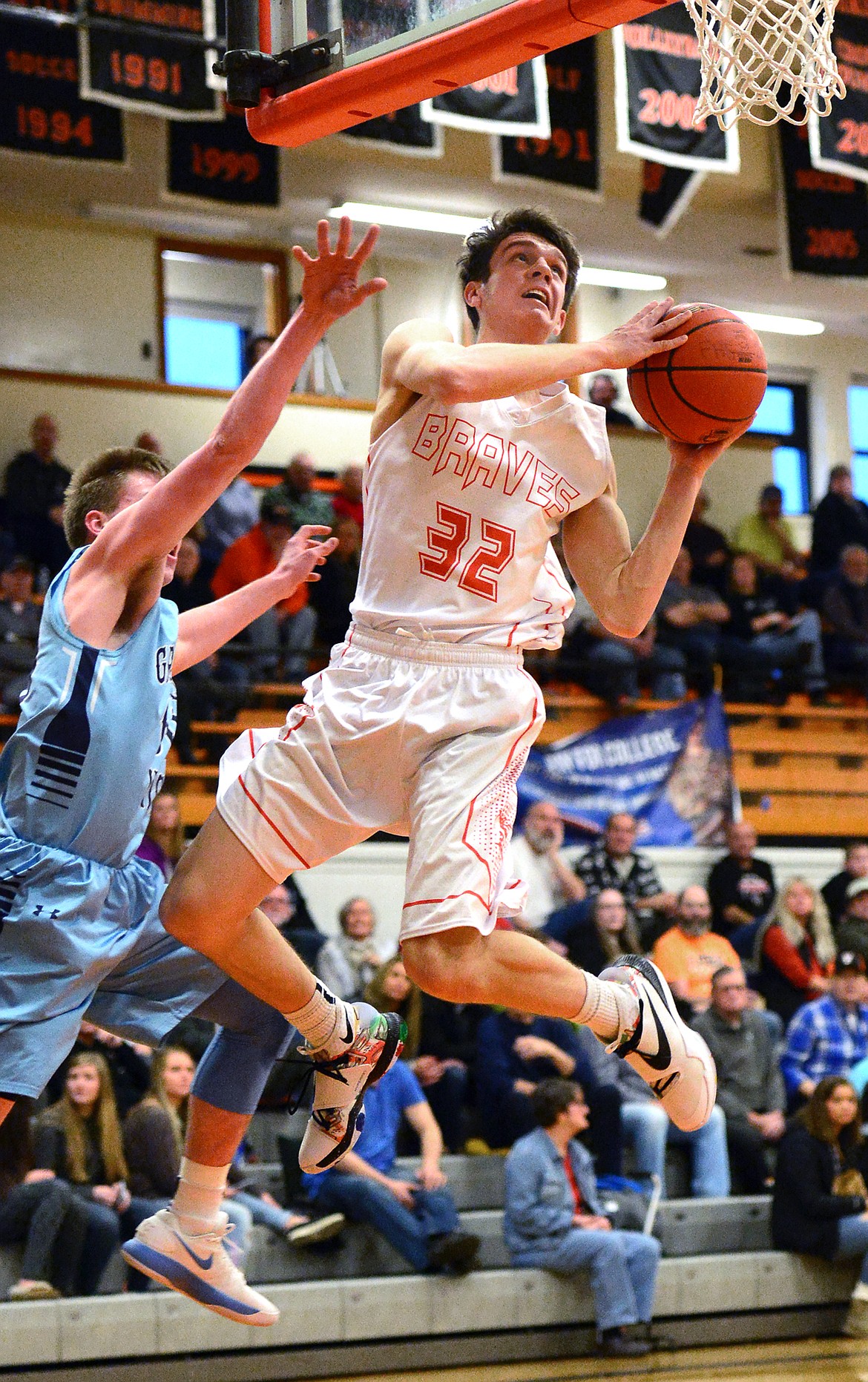 Flathead&#146;s Tyler Johnson flies under the basket for a layup against Great Falls defender Hunter McKinney in the first quarter. (Casey Kreider/Daily Inter Lake)