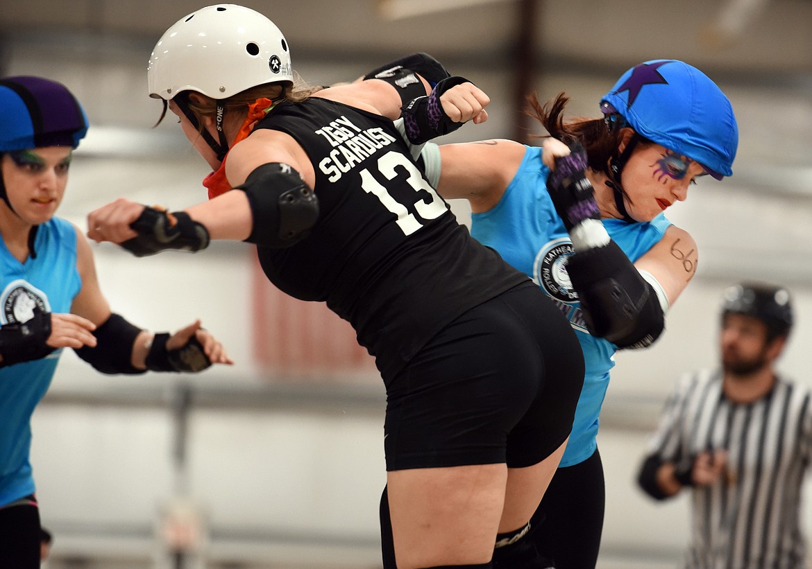 Sisters Shayna Swanson (Ruh-Roh), left, and Siina Swanson (IllumiNaughty), wearing the Jammer star, team up during the match against the Snake Pit Derby Dames of Coeur d&#146;Alene on Saturday, November 18, at the Flathead County Fairgrounds.(Brenda Ahearn/Daily Inter Lake)