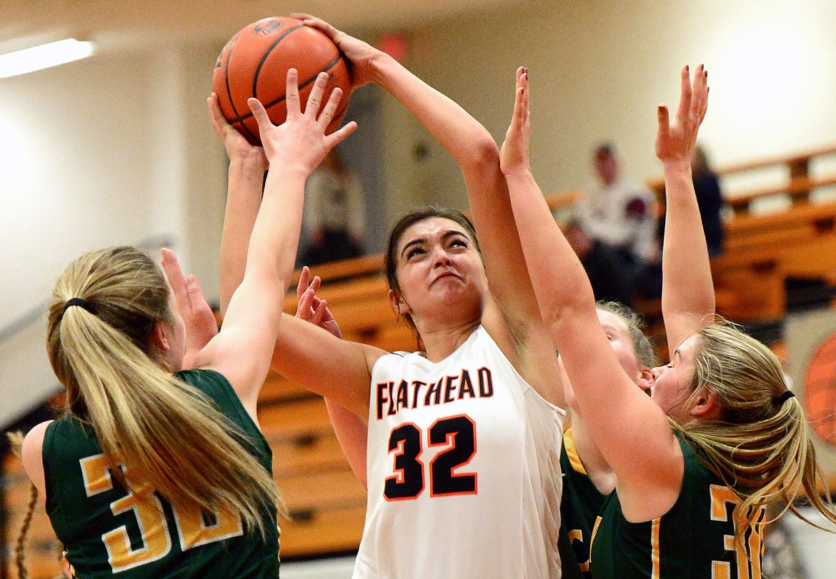 Flathead's Taylor Henley puts in two points surrounded by C.M. Russell defenders during the first half. (Casey Kreider/Daily Inter Lake)