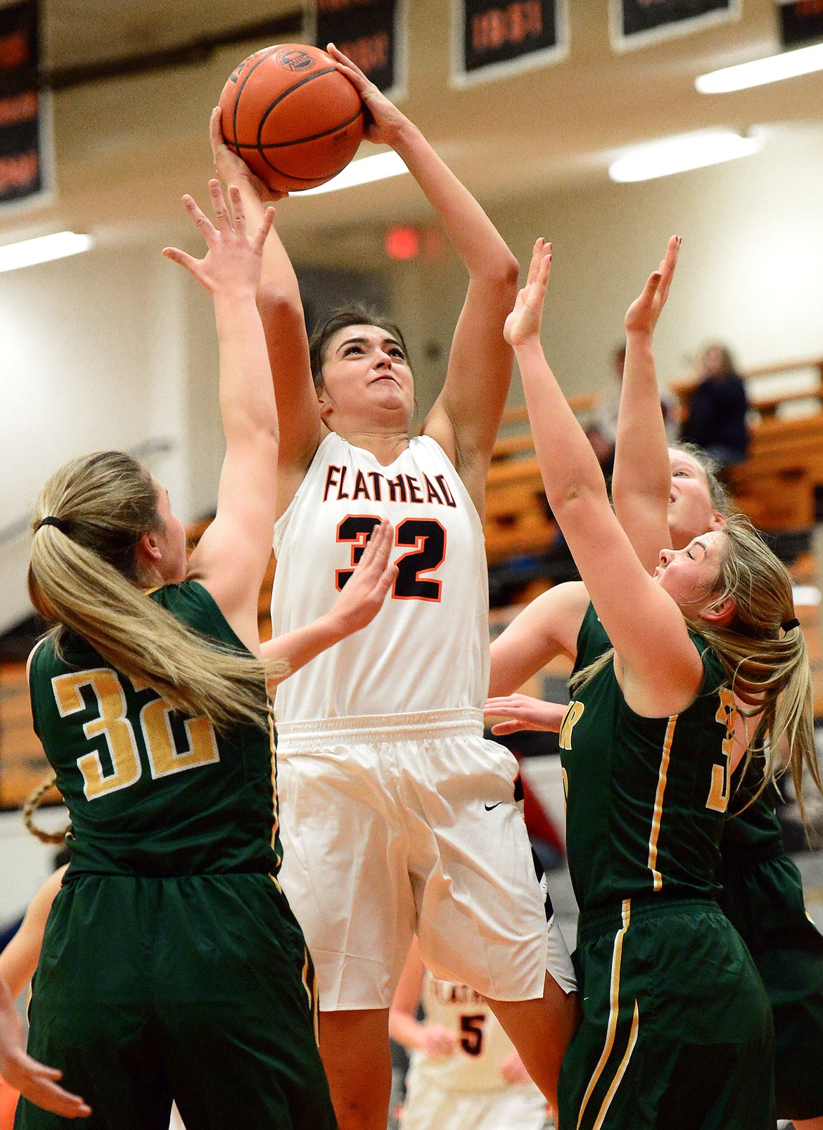 Flathead's Taylor Henley puts in two points surrounded by C.M. Russell defenders during the first half. (Casey Kreider/Daily Inter Lake)