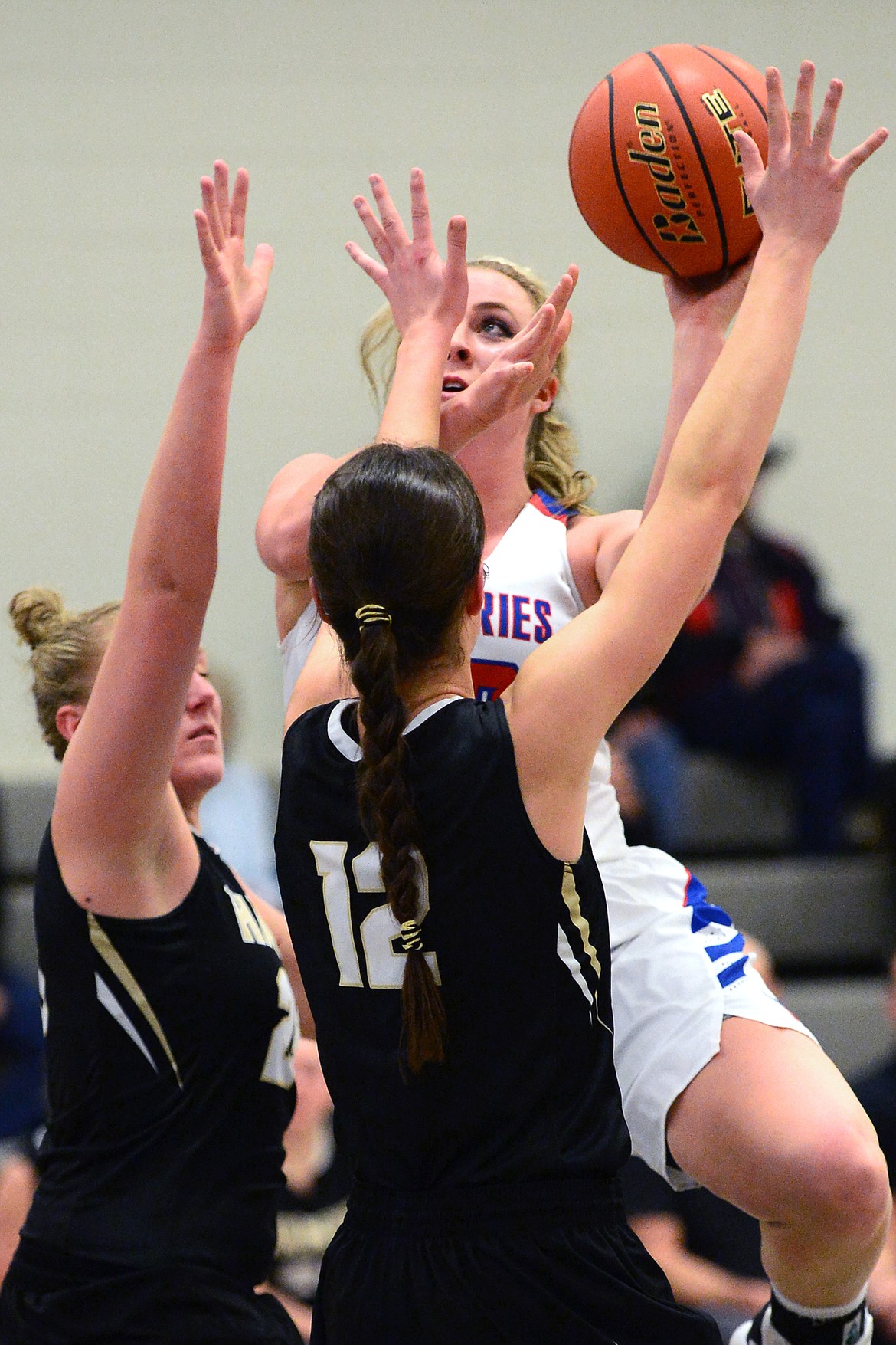 Bigfork center Jaime Berg goes to the hoop against Seeley-Swan's Chloe Robbins (25) and Klaire Kovatch (12) in the first half. (Casey Kreider/Daily Inter Lake)