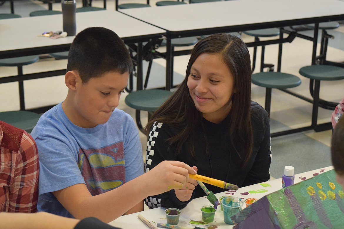 Charles H. Featherstone/Columbia Basin Herald
Ines Ramos (right) sits with Zair Cambron Thursday morning as Cambron paints a birdhouse. The two McFarland Middle School eighth-graders worked on the house, which will be a present for Cambron&#146;s family.