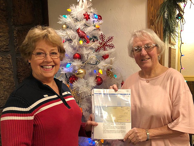 Linda Gerard, left, hands a grant check to Eileen Carney of Kootenai Pets for Life to build a receiving area for traumatized pets at the shelter.  (Courtesy photo)