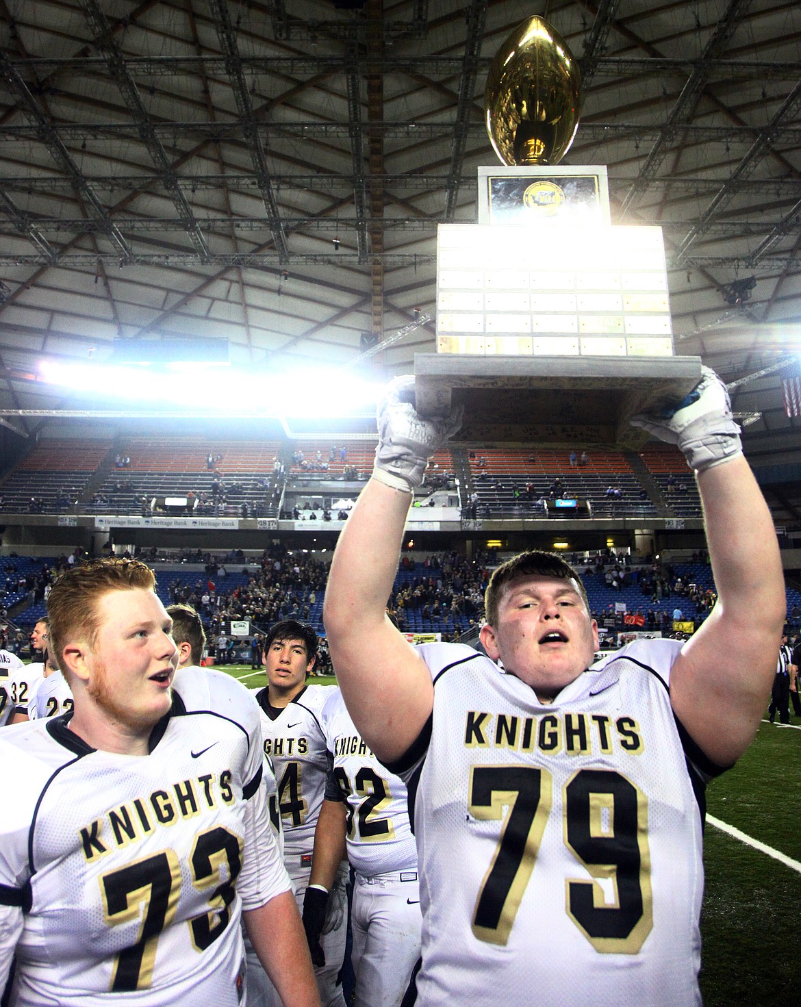 Rodney Harwood/Columbia Basin Herald
Royal senior Raynor Beierle (79) hoists the 1A state championship trophy for all to see on Saturday at the Tacoma Dome. The Knights won their third straight championship, becoming one of just seven Washington state programs to do so. See page B1 for the story and photos.