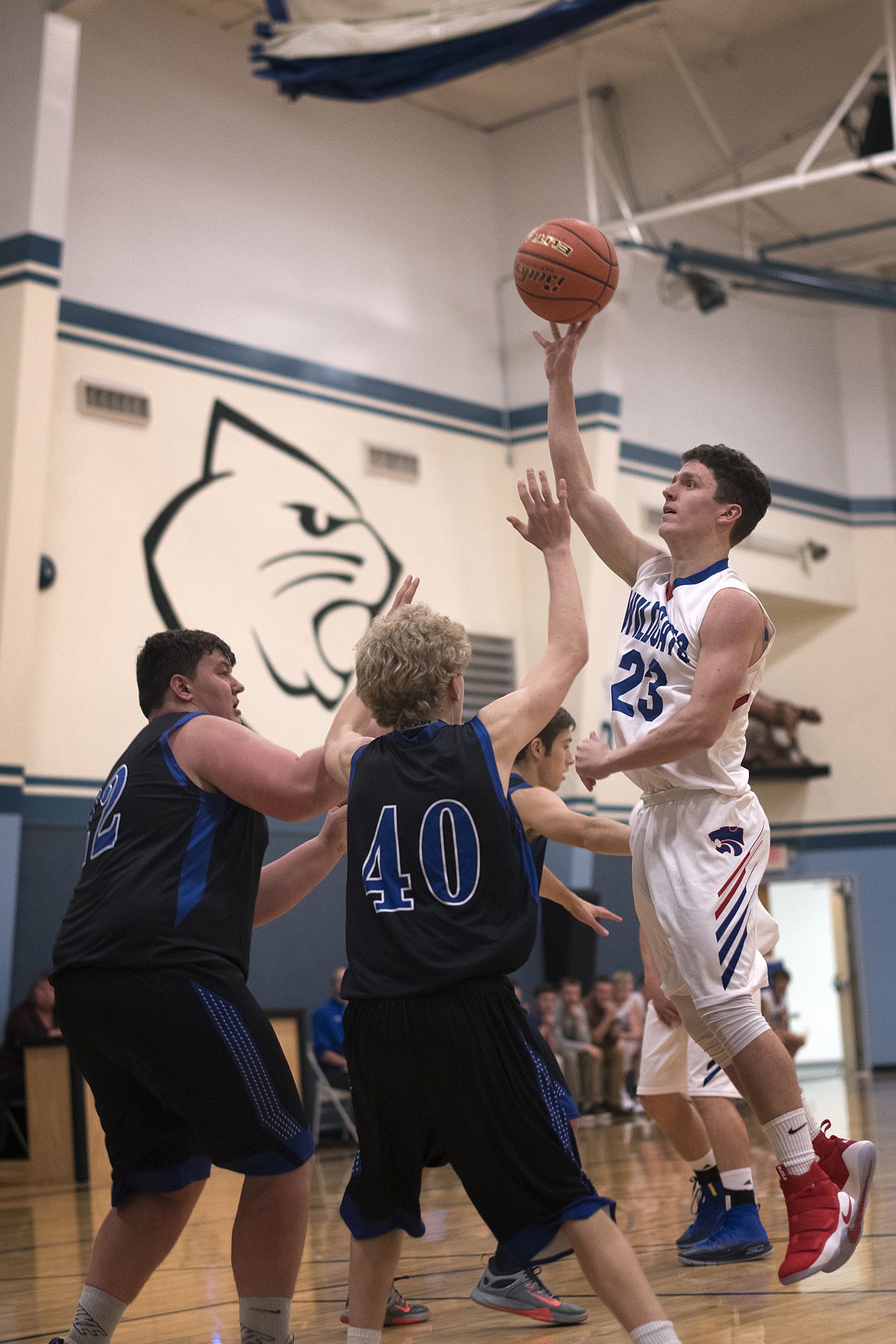 Dillon Wanner goes up for a shot over Stillwater Christian&#146;s Jeremiah Hooker (22) and Connor Drish (40). Wanner finished with three points in the Columbia Falls victory. (Jeremy Weber photo)