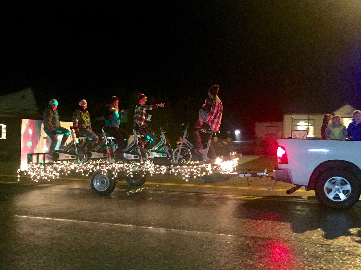 Photo by Samantha Woody/ 
Parade participants with VERS Fitnes Studio pedal away on their custom float.