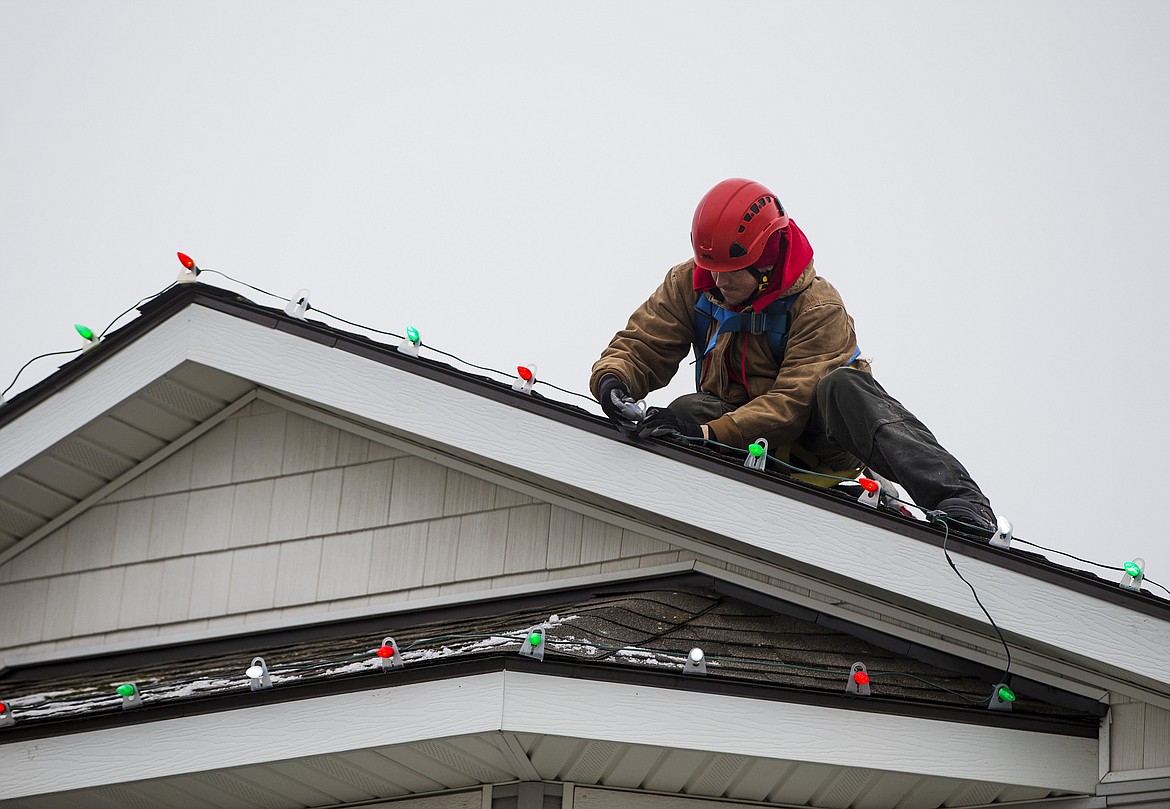 Brent Dufur with Senske Services installs a light bulb on top of Donald and Courtney Sohler&#146;s home Thursday afternoon in Coeur d&#146;Alene. (LOREN BENOIT/Press)