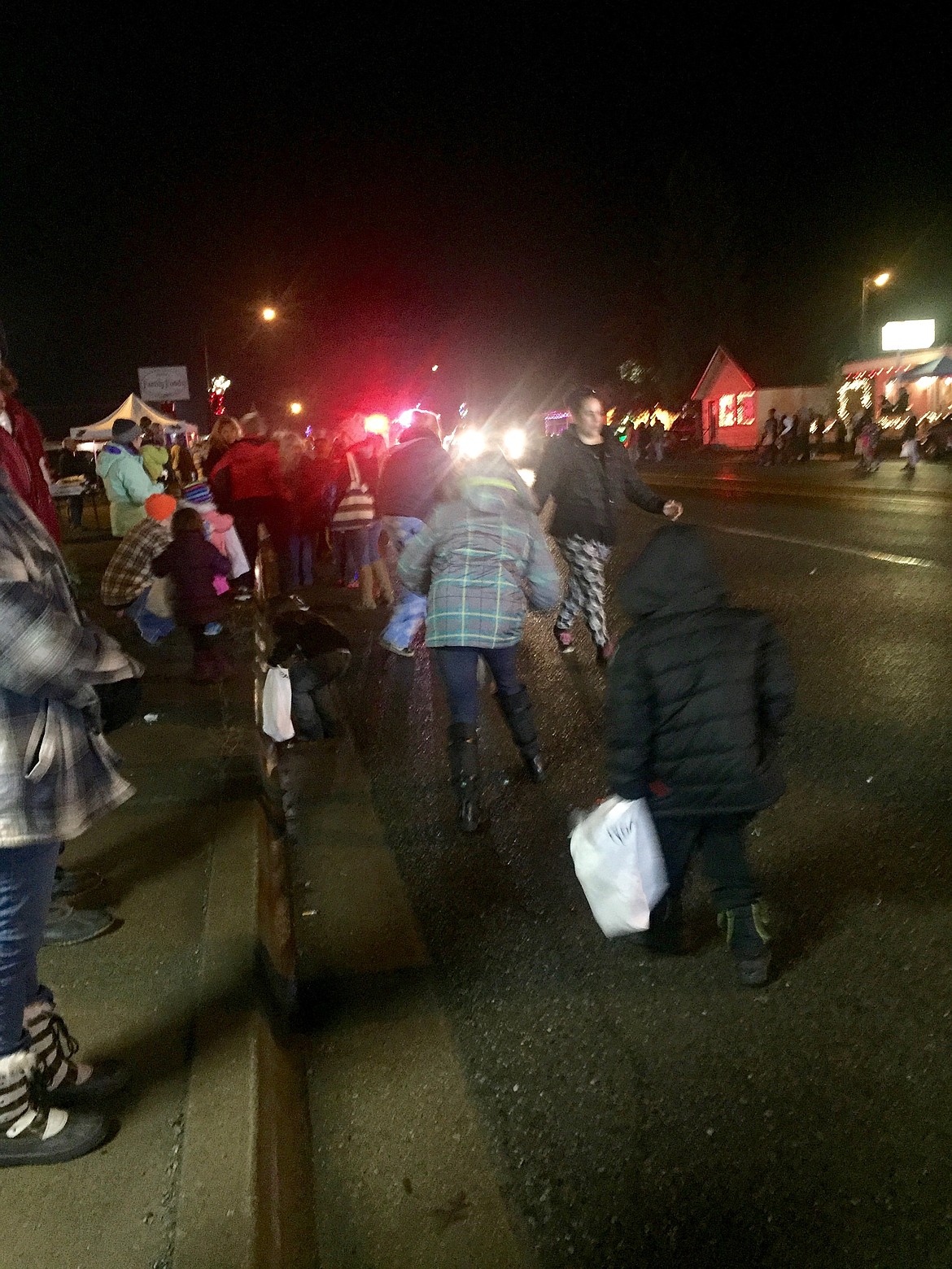 Photo by Samantha Woody/ 
Younger parade goers flock to the side of the road to grab candy thrown by a passing float.