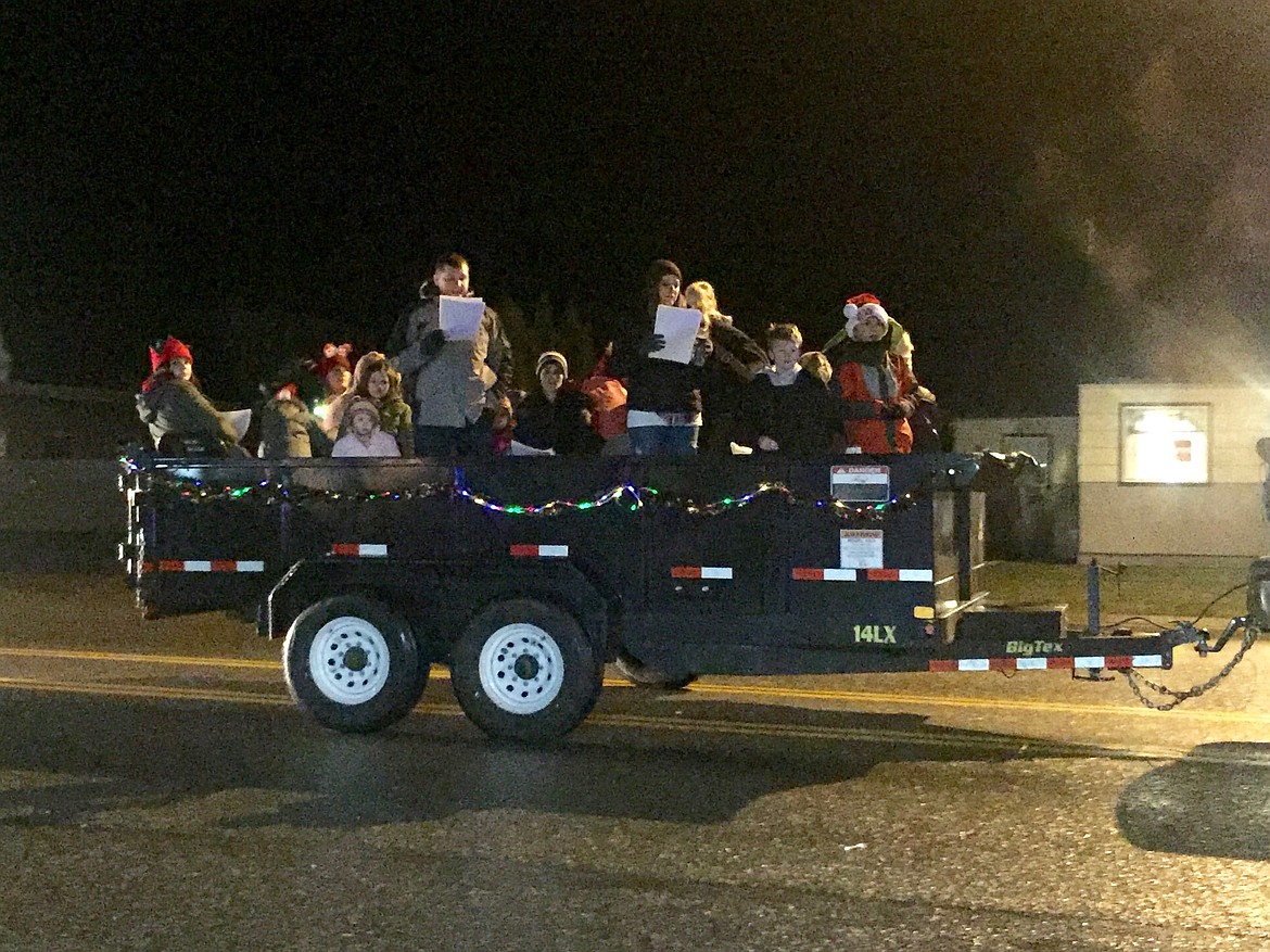 Photo by Samantha Woody/ 
Carolers sing to bystanders of the Osburn Christmas Festival parade last Saturday night.