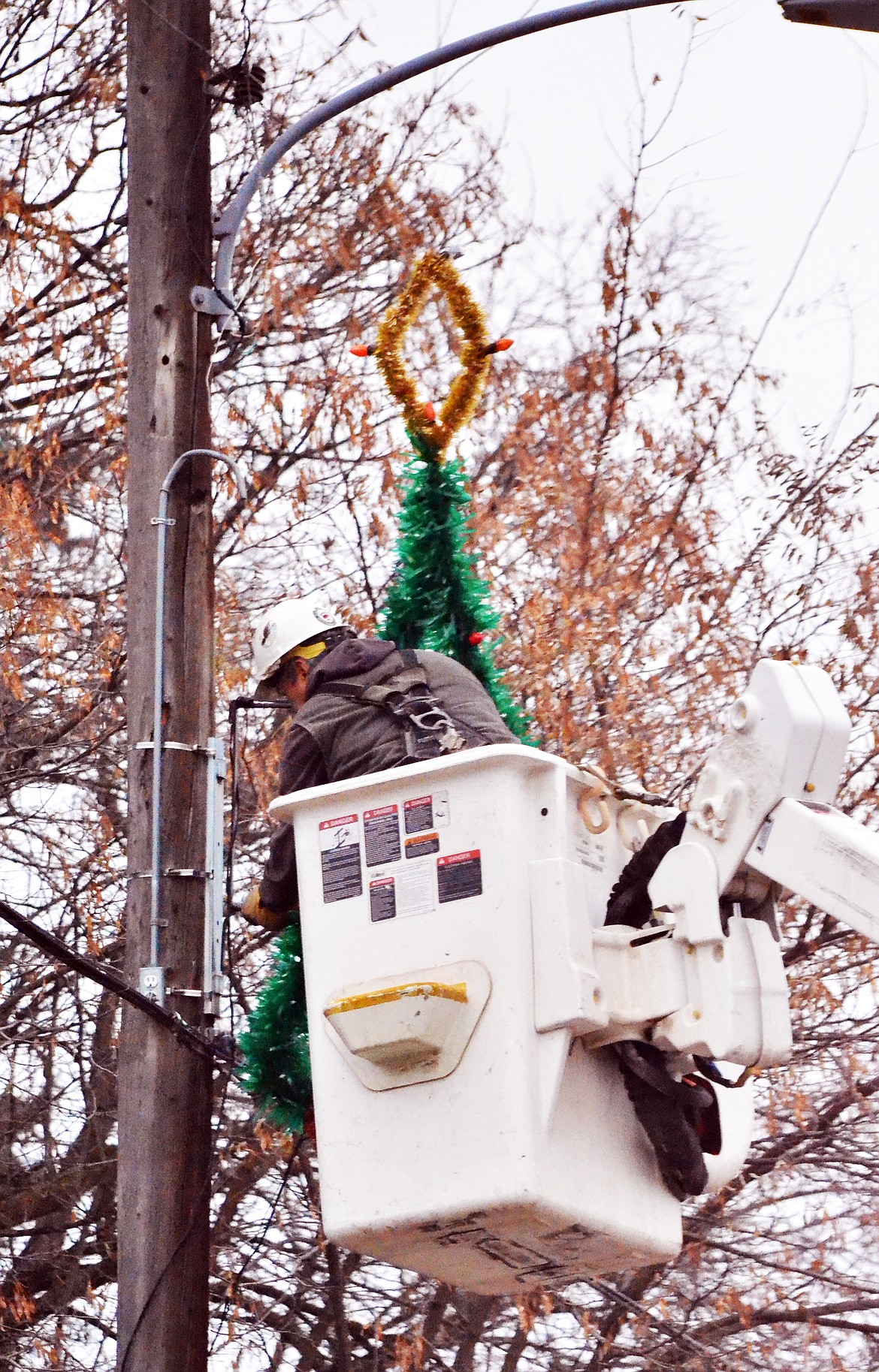 A worker from the local electrical company helps the Plains Lion&#146;s Club hang some Christmas Ornaments through the main street of the tiny town (Erin Jusseaume/ Clark Fork Valley Press)