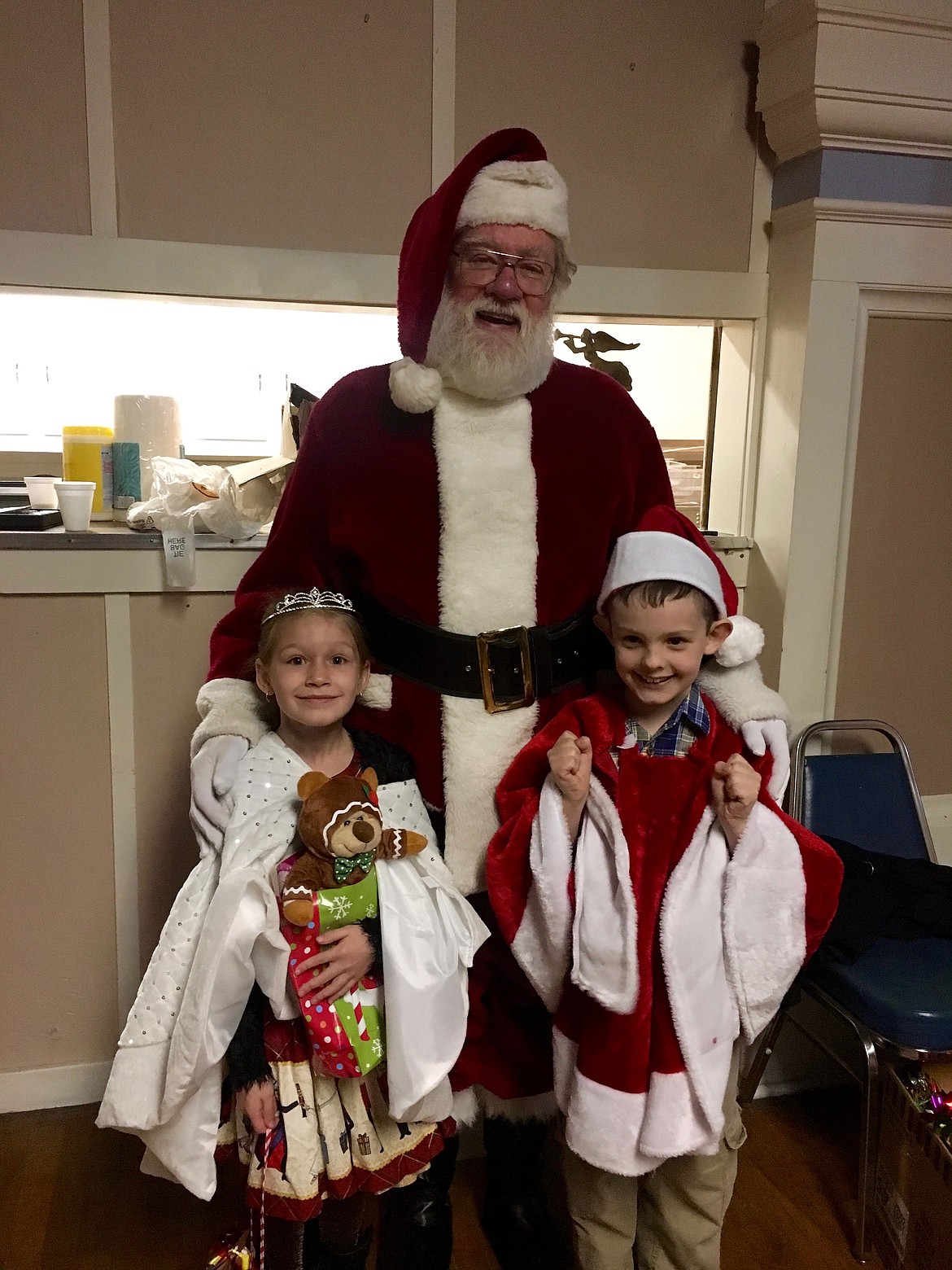 Photo by JONNIE NELSON 
Santa poses with the newly crowned Little Miss (Scarlett Almquist) and Master (Cameron McMillan) Snowflake.