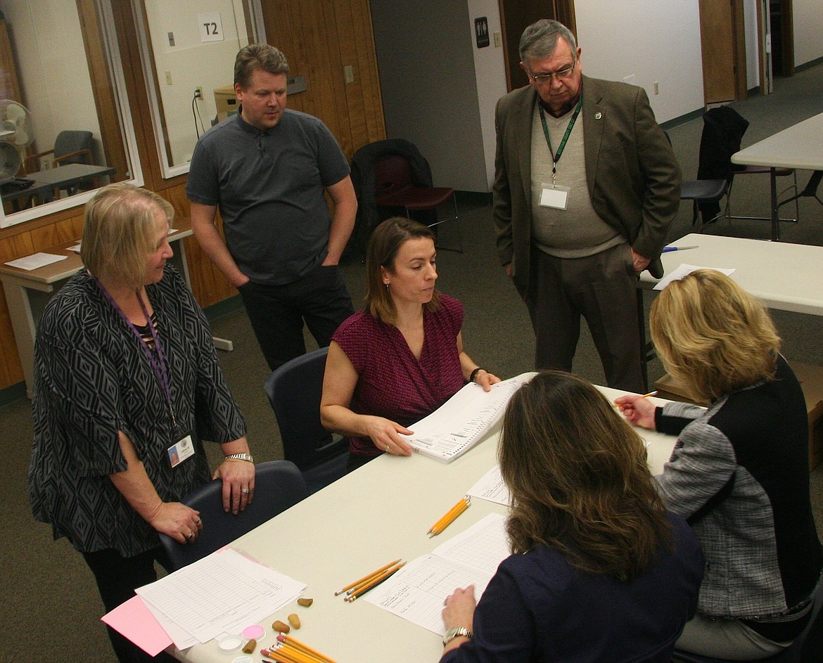 Candidate Jonathan Hall, back left, and Kootenai County Clerk Jim Brannon watch county elections employees, from left, Grace Studer, Megan Bircher, Angela Paules and Shelli Halloran count votes by hand on Wednesday.  (BRIAN WALKER/Press)