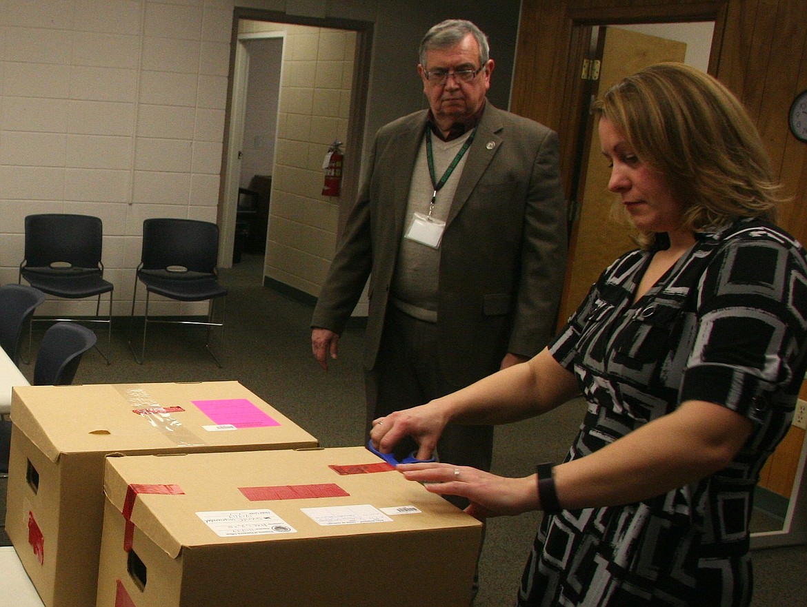 Kootenai County Elections Supervisor Carrie Phillips removes the seals of the ballot boxes prior to the recount on Wednesday while Clerk Jim Brannon looks on. (BRIAN WALKER/Press)