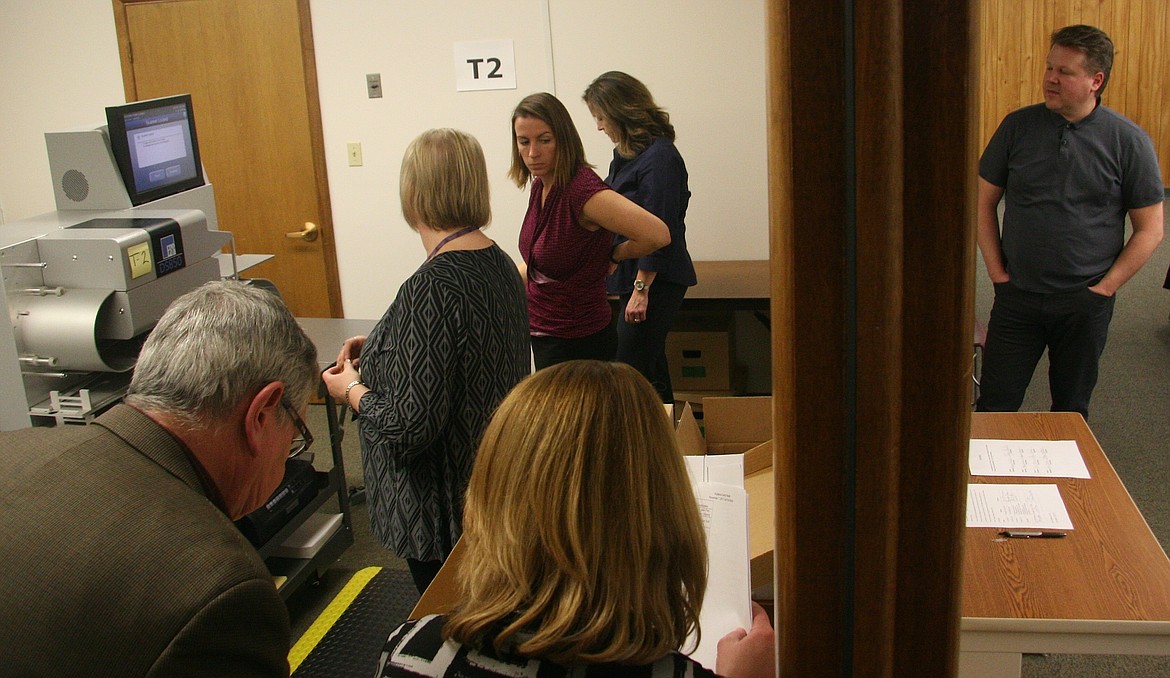 Candidate Jonathan Hall, right, watches the recount process through a window inside the electronic ballot counting room on Wednesday. (BRIAN WALKER/Press)