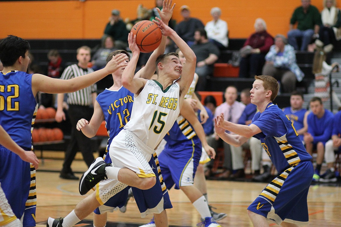 Ian Ferris, a sophomore for the Tigers, pushes his way through the Pirates on Friday in Frenchtown. Ferris and Nic Day scored 38 of the team total of 42 points in the game. (Kathleen Woodford/Mineral Independent).