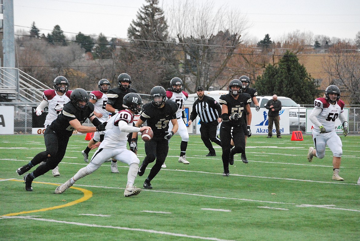 Bob Kirkpatrick/The Sun Tribune - Isaac Ellis and Jack Diaz bring down Grizzlies quarterback Koa Pancho.