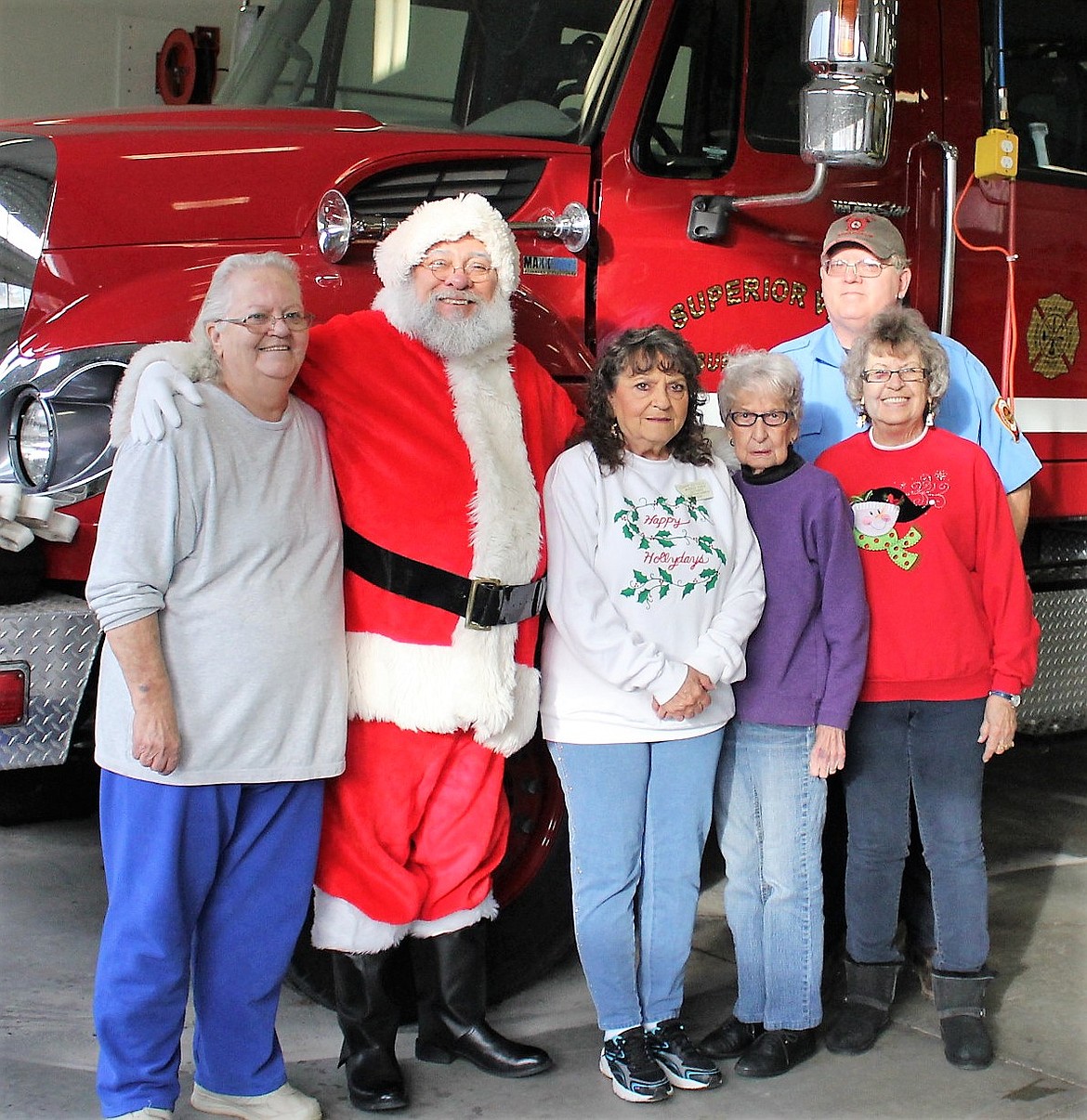 The Women in Timber hold their Parent Gift Tables at the Superior Volunteer Fire Department and Santa also comes around to visit with the kids. Left to right: Conne Ireland, Santa, Joann Merseal, Ruthie Warnken, Dee Rose and Robert Ireland. (Kathleen Woodford photos/Mineral Independent)