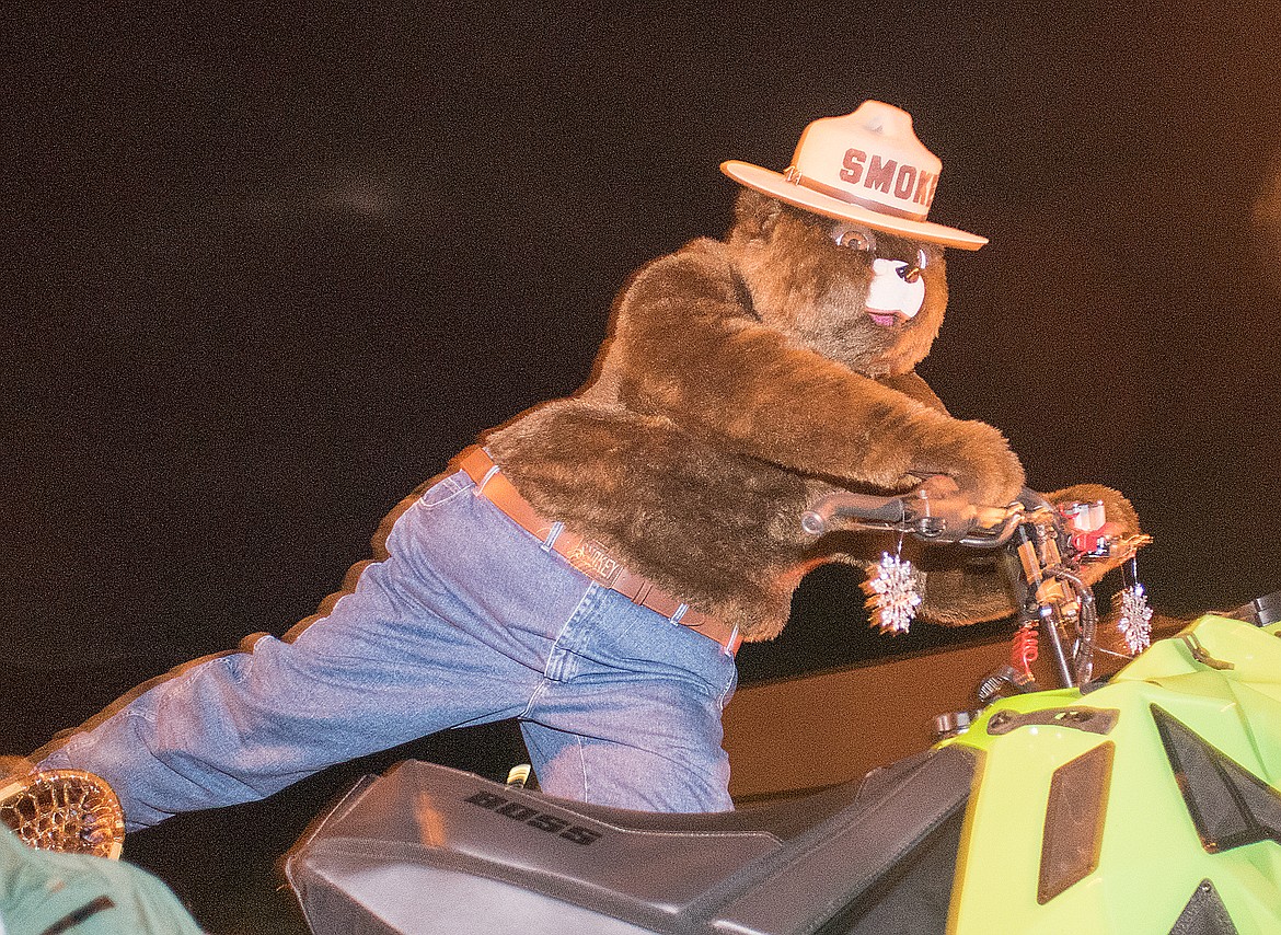 Smokey rides his snowmobile through the parade.