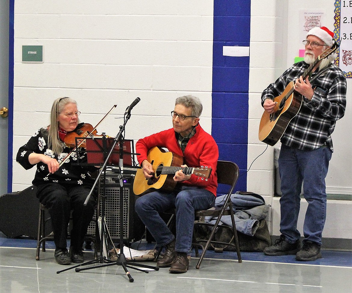 Musicians Patsey Foote, George Regan and Bear play holiday music during the Friends of the Library Craft Bazaar and Book Sale in Superior on Dec. 2. (Kathleen Woodford/Mineral Independent).