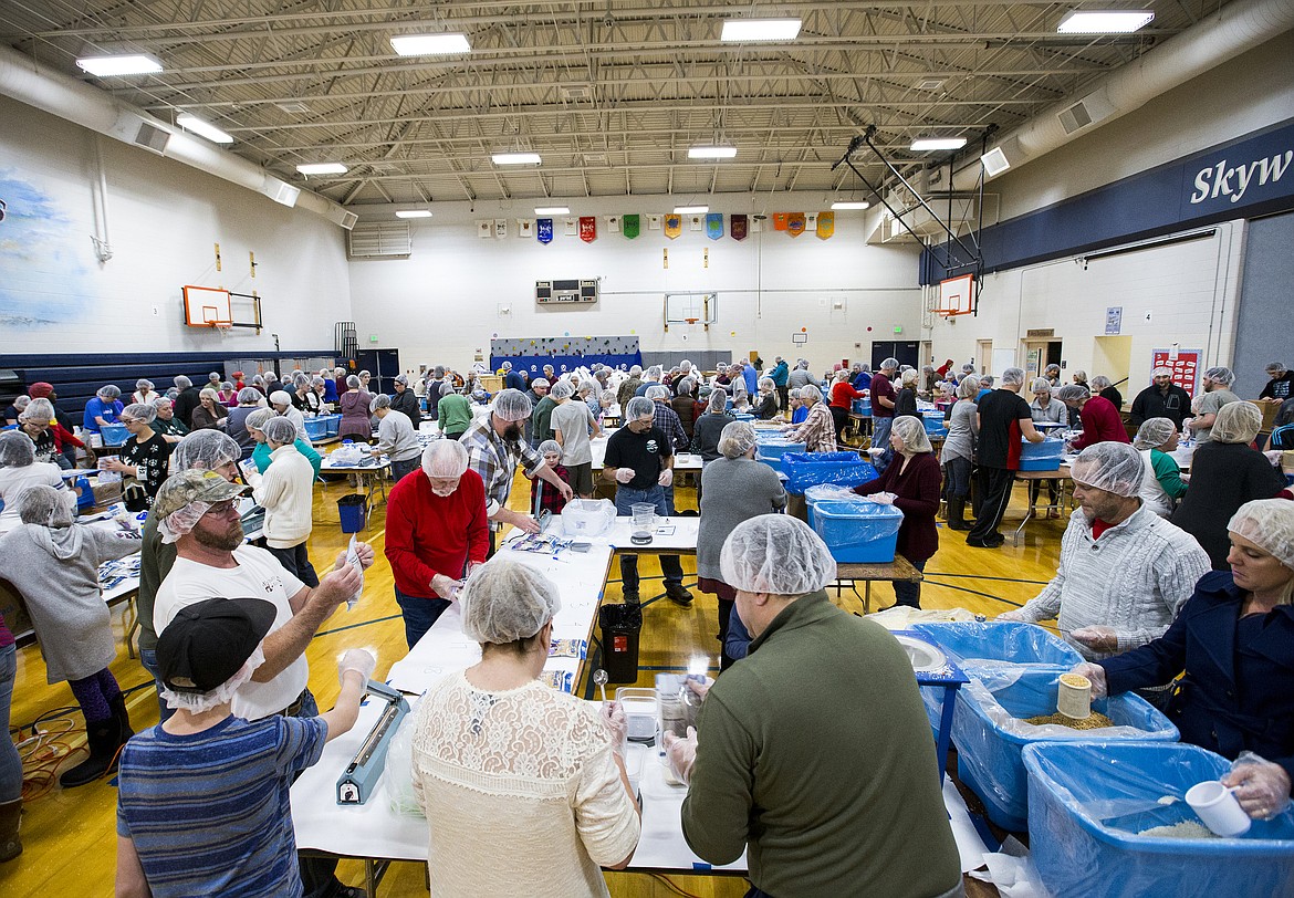 Around 500 volunteers pack meals for the Feed My Starving Children MobilePack program Friday evening at Skyway Elementary School. Around 100,000 meals were packed to send to hungry children around the world. (LOREN BENOIT/Press)