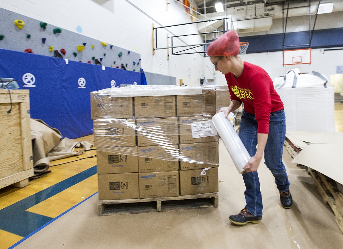 Irene Duguay wraps boxes full of MobilePacks Friday evening at Skyway Elementary School. The meals will be sent to hungry children around the world. (LOREN BENOIT/Press)