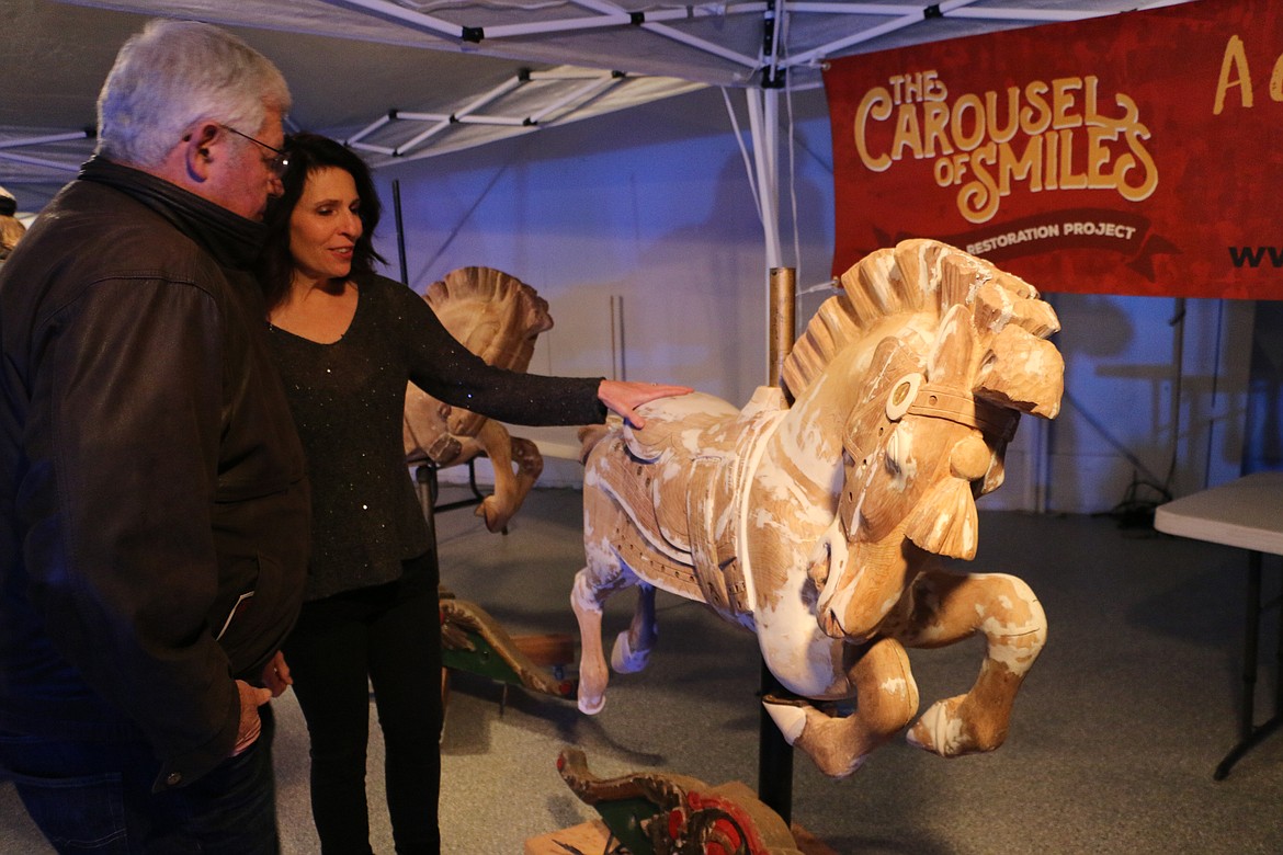 (Photo by MARY MALONE)
Reno Hutchison, right, shows off one of the ponies that was recently refinished. The Carousel of Smiles was assembled in its unrestored state and unveiled to the public last weekend.
