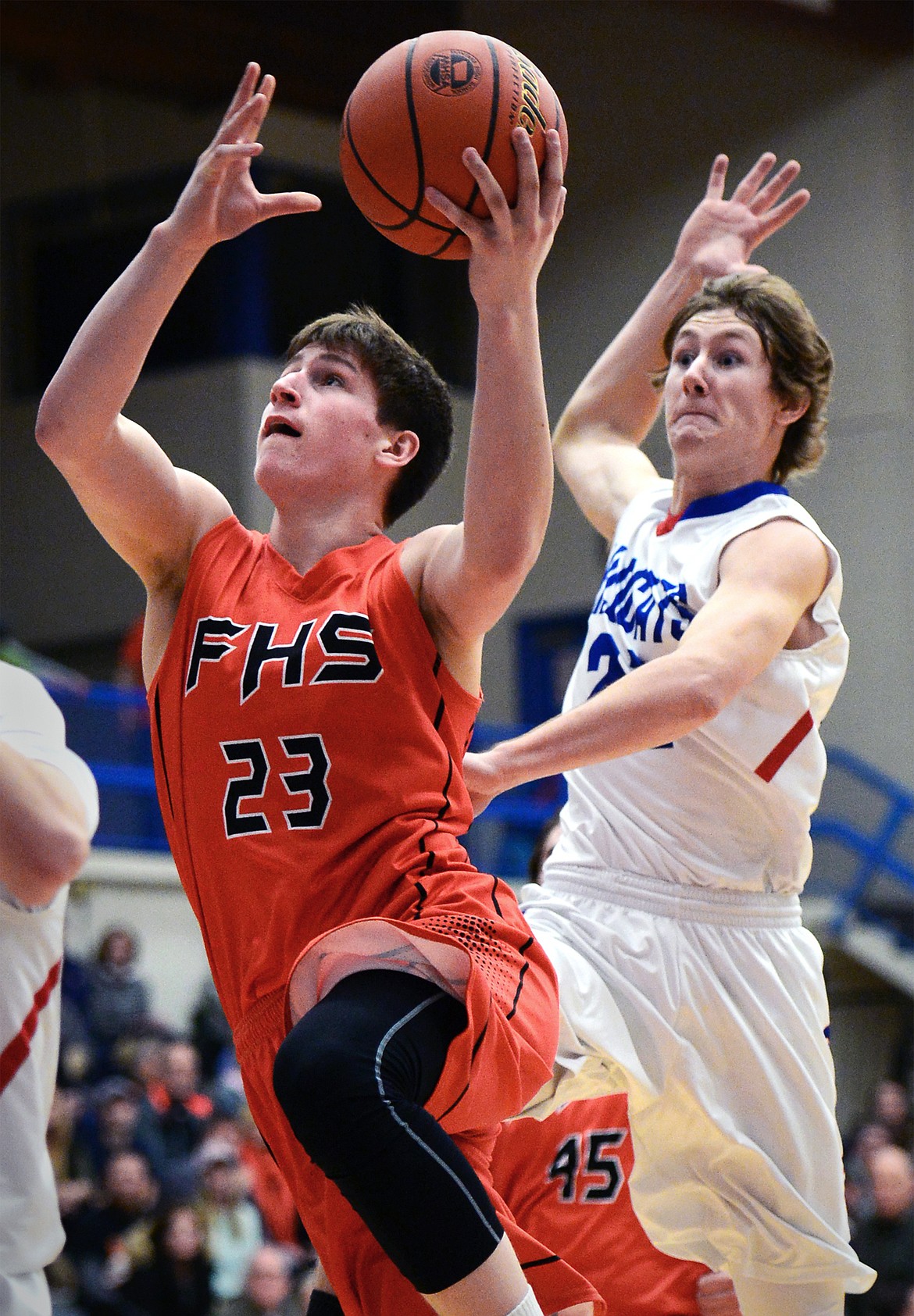 Flathead's Eric Seaman is fouled by Columbia Falls' Quintin Schriver as he drives to the hoop. (Casey Kreider/Daily Inter Lake)