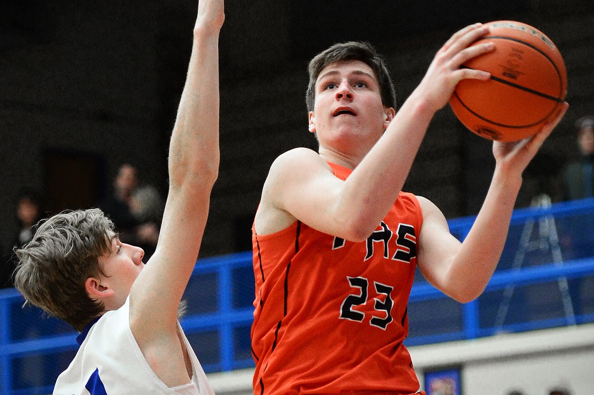 Flathead's Eric Seaman drives to the hoop past Columbia Falls defender Matthew Morrison. (Casey Kreider/Daily Inter Lake)