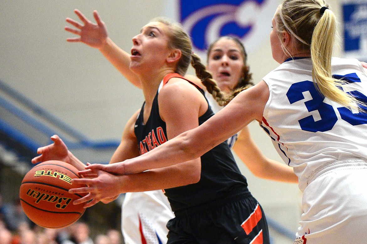 Flathead's Mary Heaton is fouled on her way to the hoop by Columbia Falls' Trista Cowan. (Casey Kreider/Daily Inter Lake)